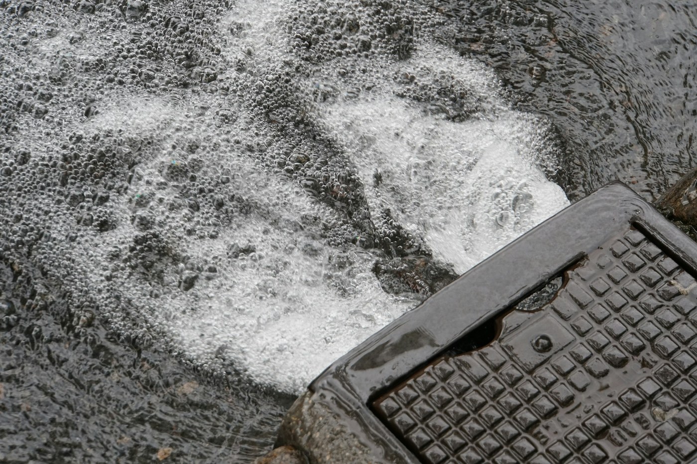 Acqua che scorre verso un chiusino stradale